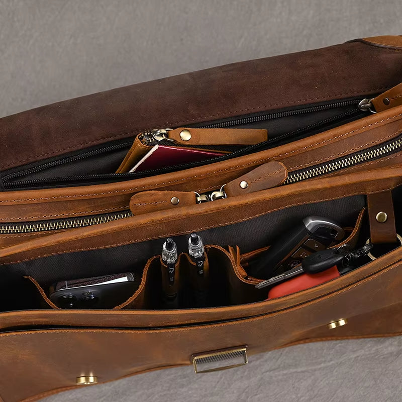 Borsa in pelle marrone aperta, con scomparti organizzati contenenti penne, chiavi e un passaporto. Design elegante e funzionale per viaggi d'affari.