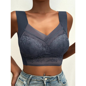 Top in pizzo blu scuro, senza maniche, con spalline larghe e scollo a V, indossato con jeans. Elegante e moderno, perfetto per moda casual.