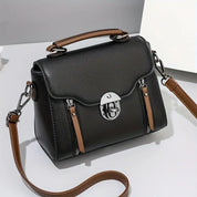 Borsa a tracolla in pelle nera con manico marrone, chiusura a scatto argentata, design elegante e moderno, accessorio moda donna.