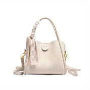 Borsa a mano bianca in pelle con manico intrecciato, decorata con foulard, tracolla regolabile e dettagli dorati. Elegante e versatile.