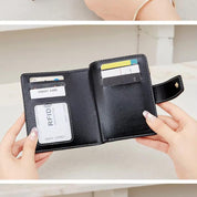 Portafoglio nero in pelle aperto con carte di credito e scomparti, design compatto, protezione RFID, accessorio elegante per uomo e donna.