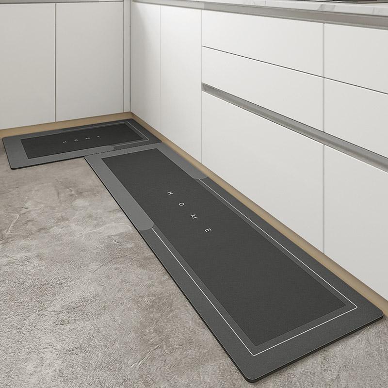 Tappeto cucina antiscivolo grigio scuro, design moderno con scritta "HOME", posizionato su pavimento in cemento, adatto per arredamento contemporaneo.