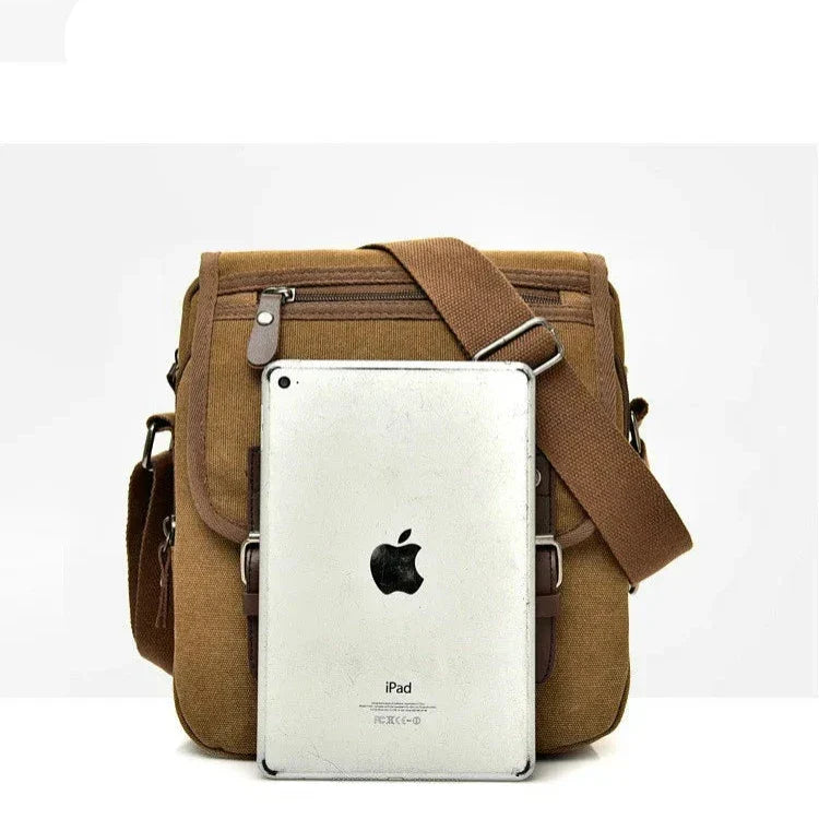Borsa a tracolla in tela marrone con tasche multiple, chiusura a zip, e cinturino regolabile, mostrata con un iPad per dimensioni.