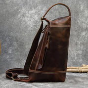 Zaino in pelle marrone vintage, design elegante e resistente, con cerniera laterale e tracolla regolabile. Ideale per viaggi e uso quotidiano.
