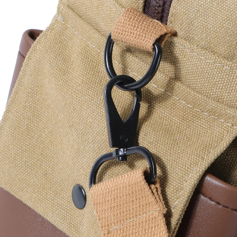 Zaino in tela beige con dettagli in pelle marrone, gancio in metallo nero e cuciture visibili. Design robusto e funzionale per uso quotidiano.