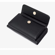 Portafoglio nero in pelle aperto con chiusura a bottone, design elegante e compatto, ideale per uomo e donna. Accessorio moda di alta qualità.