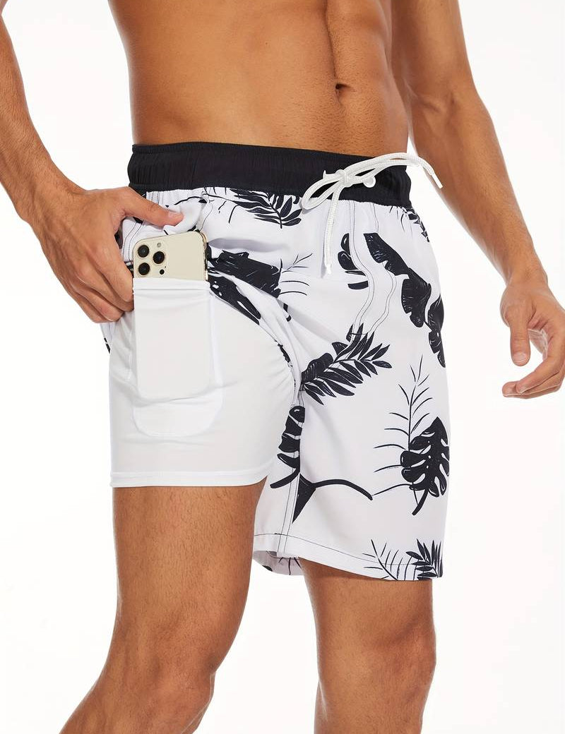 Shorts da bagno uomo bianchi con stampa foglie nere, tasca laterale per smartphone, elastico in vita, perfetti per spiaggia e piscina.