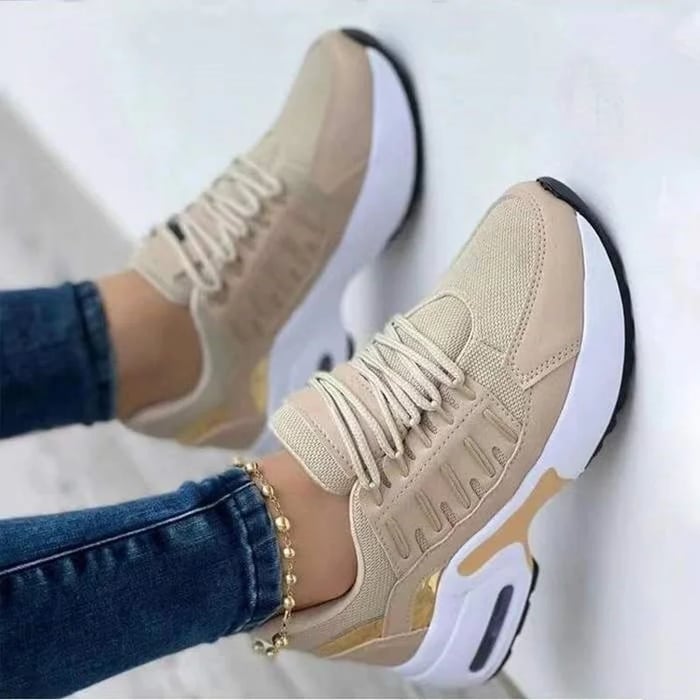 Scarpe da ginnastica beige da donna, suola bianca, dettagli dorati, indossate con jeans. Sneakers moda casual, comode e trendy.