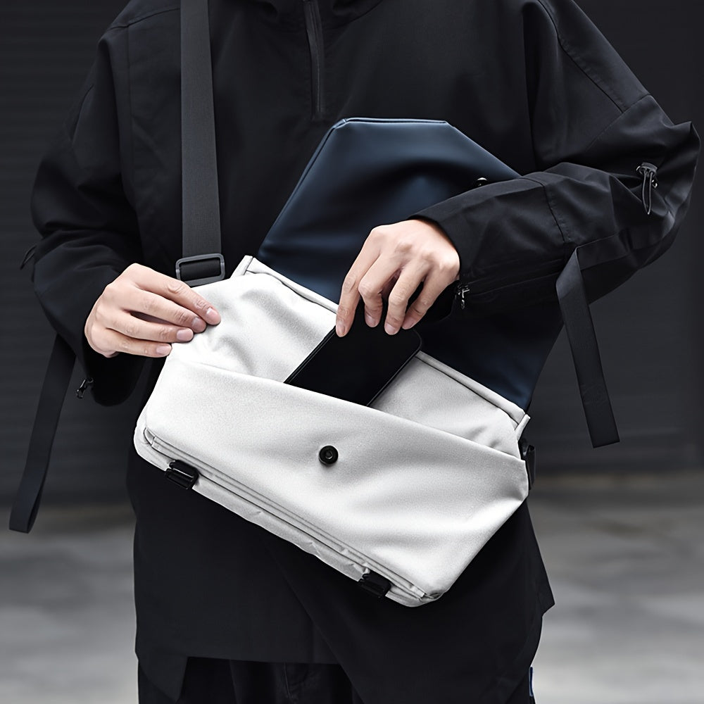 Borsa a tracolla moderna in tessuto bianco, con tasca frontale e chiusura a bottone, indossata da una persona in abbigliamento nero.