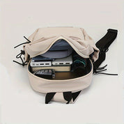 Zaino beige aperto con tasche multiple, contenente dispositivi elettronici e accessori. Design moderno, ideale per viaggi e lavoro.