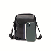 Borsa a tracolla in pelle nera con dettagli a righe, affiancata da uno smartphone moderno. Design elegante e funzionale per uomo.