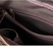 Interno borsa in pelle marrone con cerniere dorate, tasche multiple. Design elegante e funzionale per moda e accessori donna.