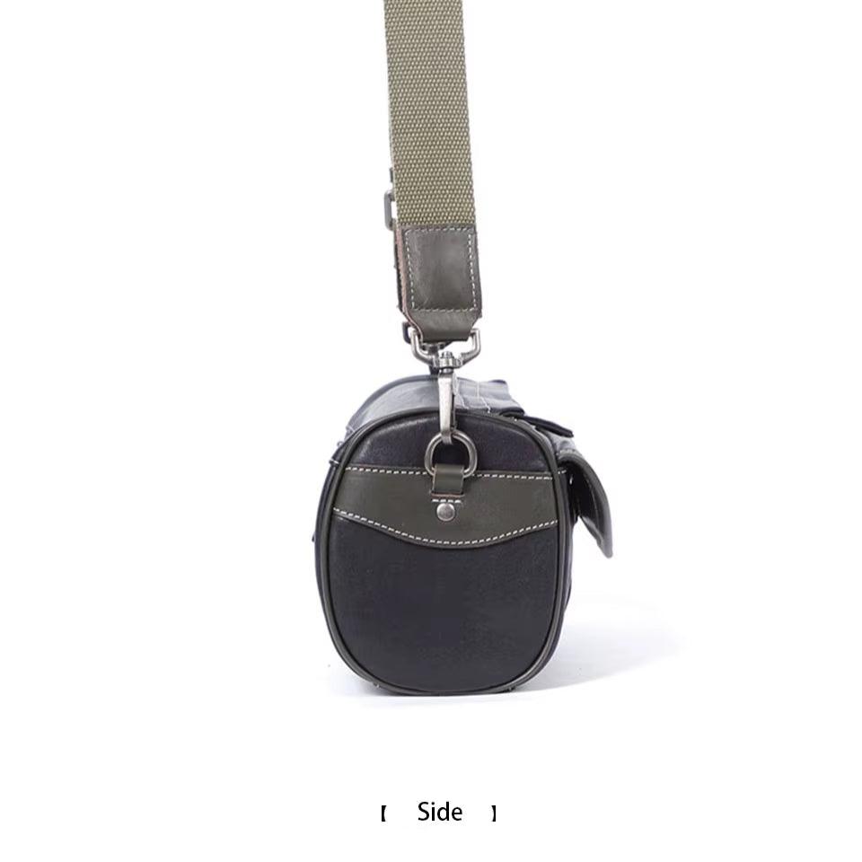 Borsa a tracolla in pelle nera con dettagli in tessuto, vista laterale. Design elegante, ideale per uomo e donna. Accessorio moda versatile.