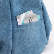Zaino in tessuto blu con tasca contenente carte di credito. Accessorio moda pratico per viaggi e scuola. Design moderno e funzionale.