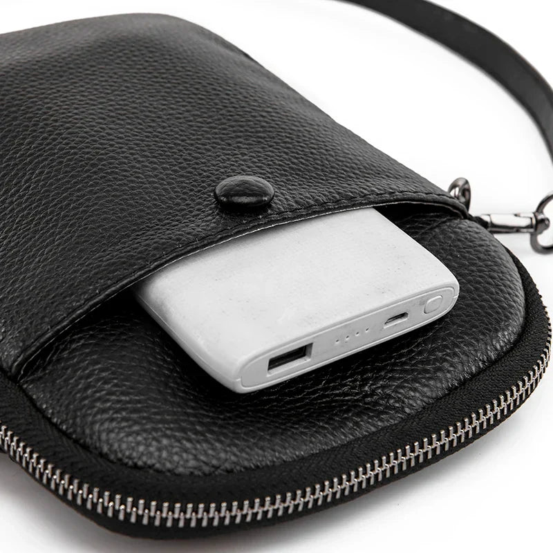 Custodia in pelle nera con power bank bianco, chiusura a zip e bottone. Accessorio elegante e pratico per ricarica dispositivi in movimento.