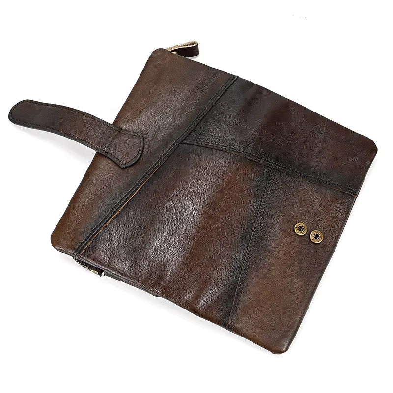 Borsa a mano in pelle marrone scuro, design elegante con chiusura a zip e dettagli a bottoni, accessorio moda uomo e donna, stile vintage.