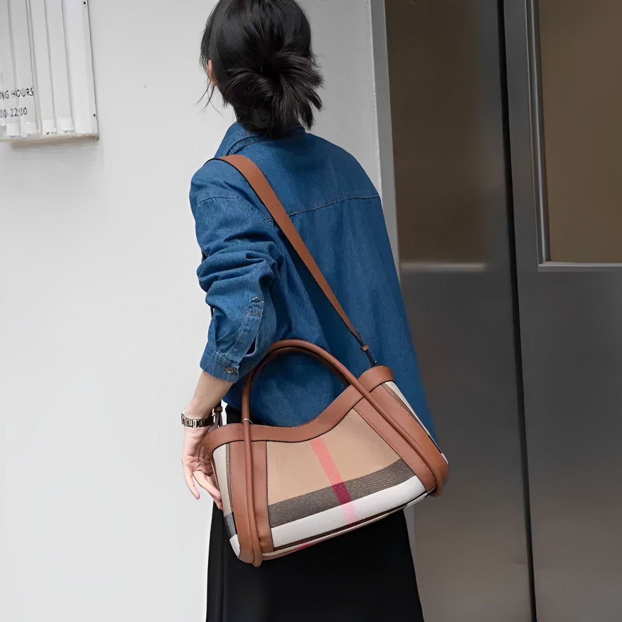 Donna con borsa a tracolla in pelle marrone e tessuto a righe, indossa camicia di jeans. Stile casual chic, moda autunnale, accessori eleganti.