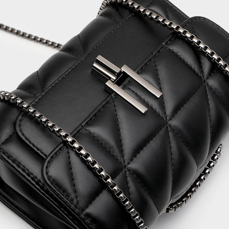 Borsa a tracolla nera trapuntata in pelle con catena metallica e chiusura a gancio. Design elegante e moderno, accessorio moda di tendenza.