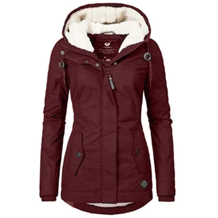 Giacca invernale donna bordeaux con cappuccio foderato in pelliccia sintetica, chiusura zip, bottoni, tasche frontali. Elegante e calda.