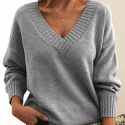 Maglione donna grigio con scollo a V, maniche lunghe, tessuto morbido, stile casual chic, perfetto per autunno inverno.