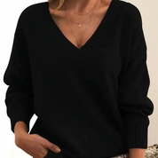 Maglione nero da donna con scollo a V, maniche lunghe, indossato con collane dorate. Elegante e versatile per moda autunnale e invernale.