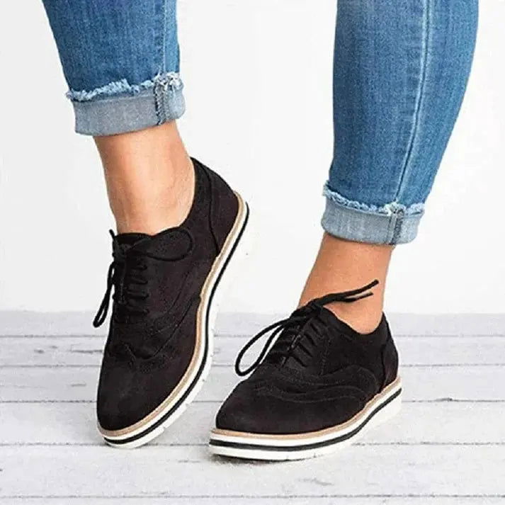 Scarpe da corsa bianche e nere su sfondo bianco, design moderno, suola ammortizzata, ideali per jogging e sport all'aperto.