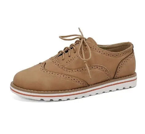Scarpa brogue da donna in pelle marrone chiaro, suola bianca dentellata, design elegante e casual, perfetta per moda autunnale e primaverile.