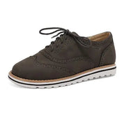 Scarpa stringata da uomo in pelle marrone scuro, stile brogue, suola bianca dentellata. Elegante e casual, perfetta per ogni occasione.