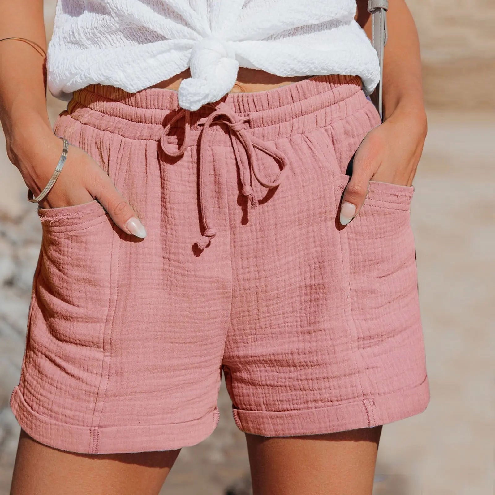 Shorts rosa in cotone leggero con tasche, indossati da una donna. Stile casual estivo, perfetti per giornate calde. Moda donna, abbigliamento estivo.