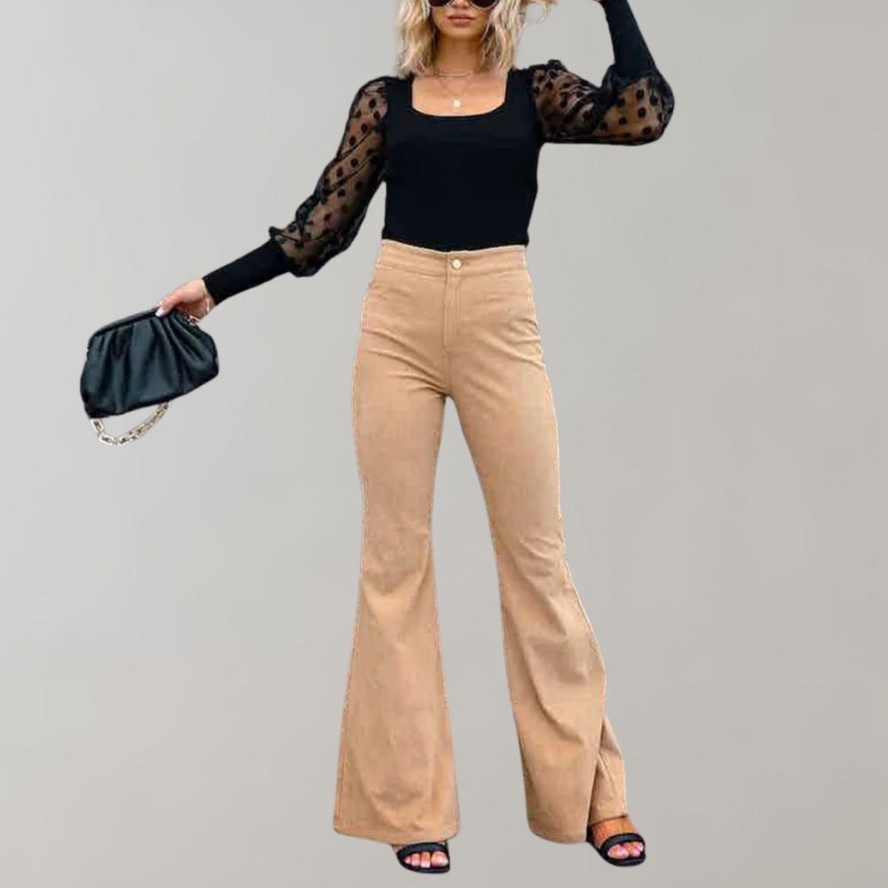 Donna con top nero trasparente a pois, pantaloni a zampa beige, borsa nera e sandali. Moda elegante, abbigliamento casual chic, tendenze 2023.