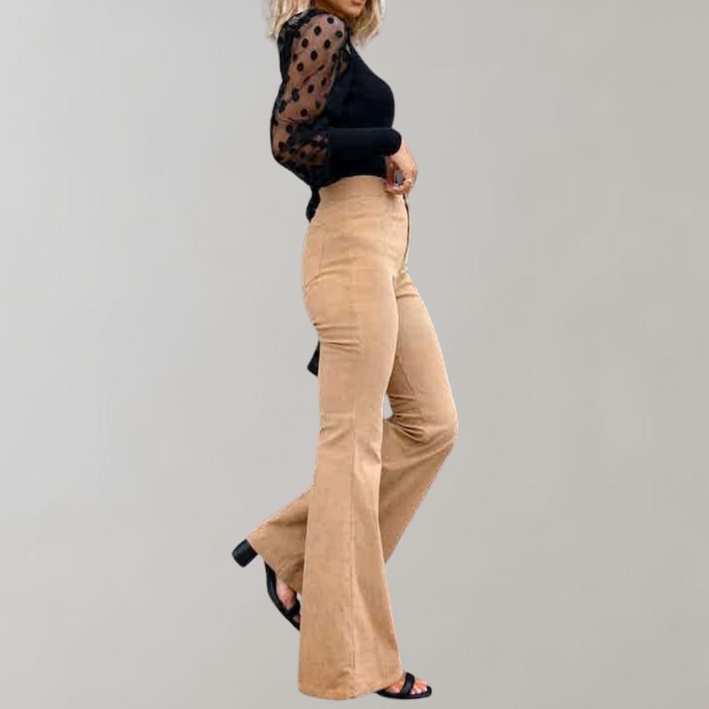 Pantaloni a zampa beige donna, abbinati a maglia nera con maniche a pois trasparenti. Moda femminile elegante, stile casual chic.