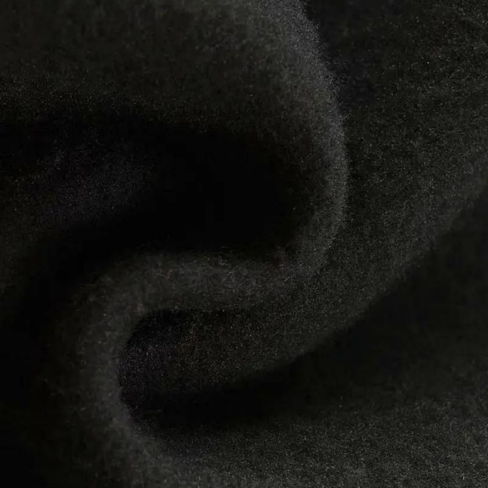 Tessuto in lana nera, morbido e caldo, ideale per abbigliamento invernale. Texture soffice, perfetta per cappotti e giacche eleganti.