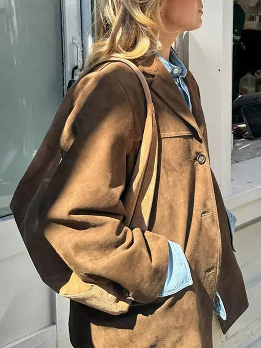 Giacca in pelle scamosciata marrone da donna, stile casual, abbinata a camicia di jeans. Moda autunnale, abbigliamento femminile elegante.