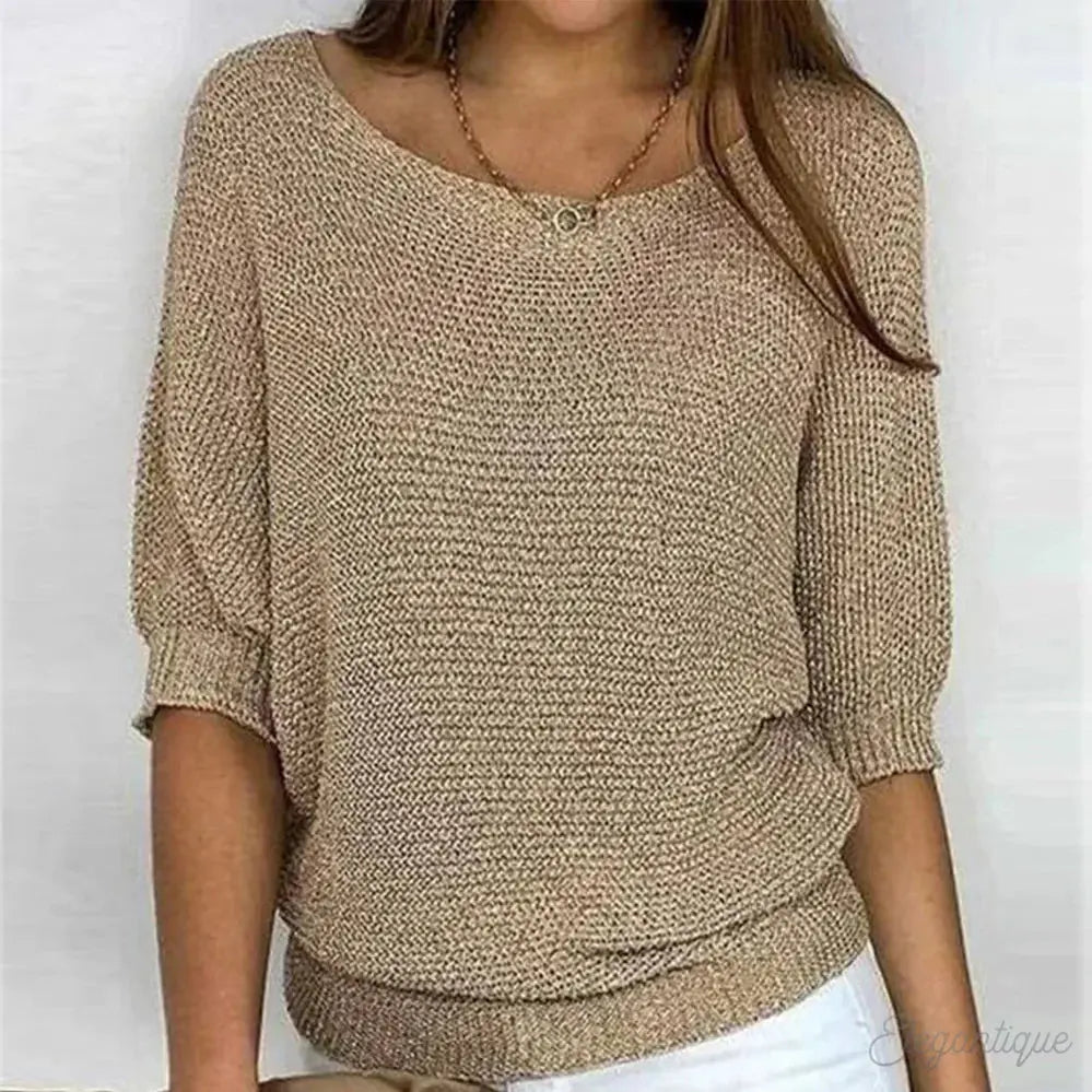 Maglione donna beige a maglia larga, maniche corte, scollo rotondo, abbinato a pantaloni bianchi. Stile casual elegante, moda autunnale.