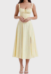 Abito midi giallo chiaro con spalline larghe, scollo a cuore e spacco frontale. Elegante e femminile, perfetto per occasioni estive.