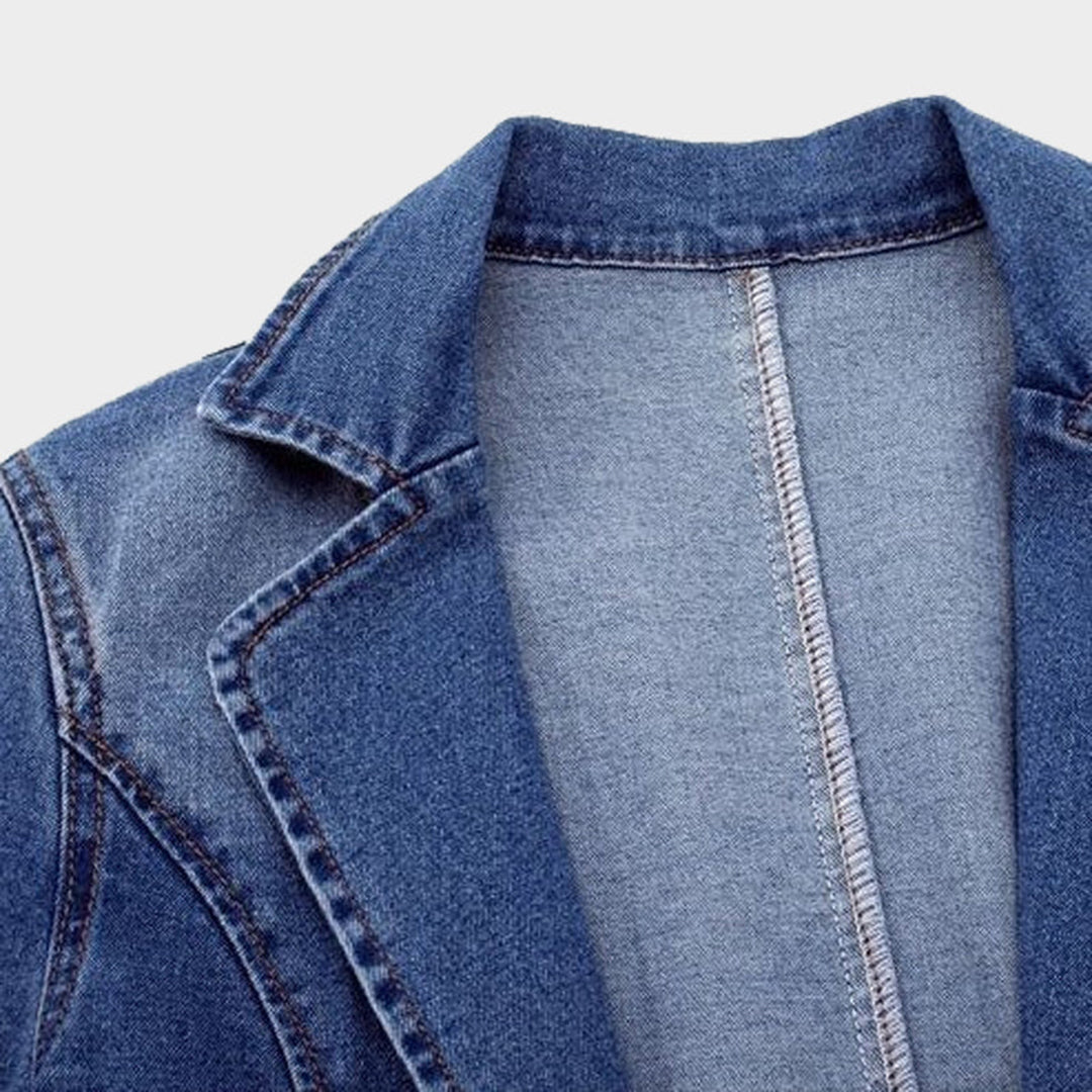 Giacca di jeans in denim blu, cuciture a vista, colletto classico, moda casual, abbigliamento uomo e donna, tessuto resistente, stile versatile.