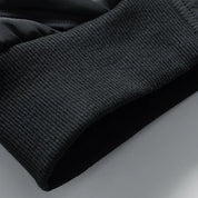 Polsino elastico nero in tessuto a coste, dettaglio di una felpa sportiva. Design moderno, ideale per abbigliamento casual e sportivo.