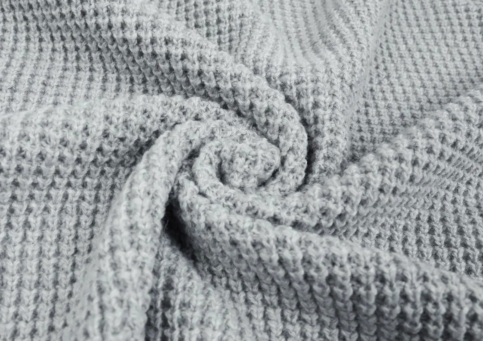 Tessuto a nido d'ape grigio chiaro, texture morbida e accogliente, ideale per coperte e abbigliamento invernale. Materiale caldo e traspirante.