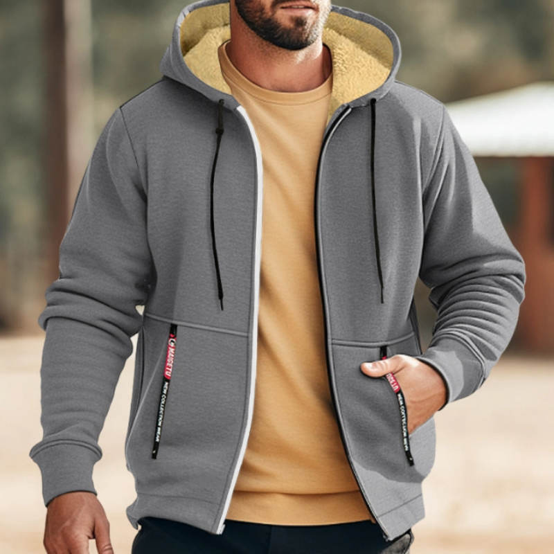 Giacca con cappuccio grigia da uomo, foderata in pile, con cerniera e tasche frontali. Abbigliamento casual autunnale, moda maschile comoda.