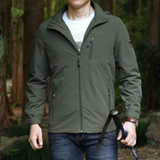 Giacca verde da uomo per escursionismo, impermeabile e antivento, con cerniera e tasche, ideale per attività outdoor e trekking in montagna.