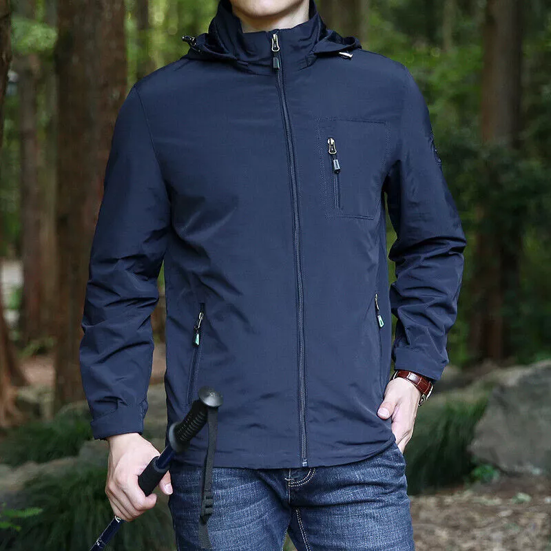 Giacca impermeabile blu scuro da uomo, con cappuccio e zip, indossata in ambiente boschivo. Ideale per escursioni e attività outdoor.
