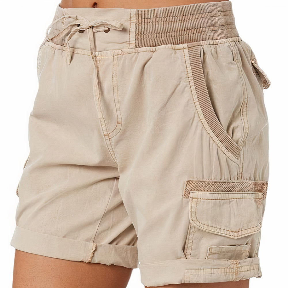 Shorts cargo beige da donna con tasche multiple, elastico in vita e orlo risvoltato. Design casual, ideale per l'estate e attività all'aperto.