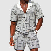 Set coordinato uomo a quadri bianco e nero, camicia a maniche corte e pantaloncini, stile casual estivo, moda maschile elegante.