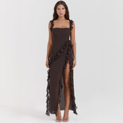 Abito lungo elegante nero con volant, spacco laterale, senza maniche. Perfetto per eventi serali e cerimonie. Moda donna, abbigliamento formale.