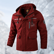 Giacca invernale rossa da uomo con cappuccio, tasche multiple e dettagli riflettenti, ideale per escursioni in montagna. Tessuto resistente e caldo.