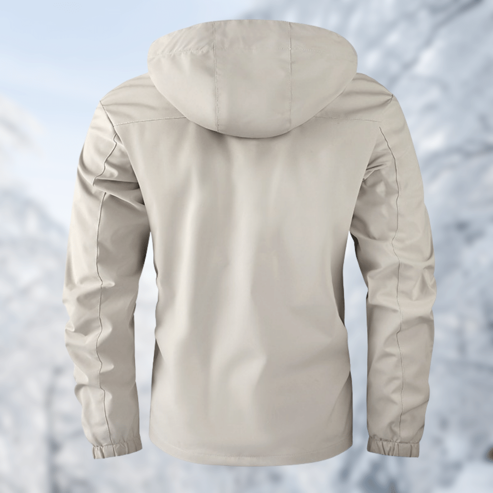 Giacca impermeabile beige con cappuccio, vista posteriore, su sfondo invernale. Abbigliamento outdoor, antivento, ideale per escursioni e sport invernali.