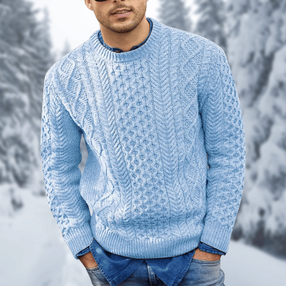 Maglione uomo invernale azzurro a trecce, indossato su camicia di jeans, sfondo innevato. Maglione caldo, moda uomo, abbigliamento casual.