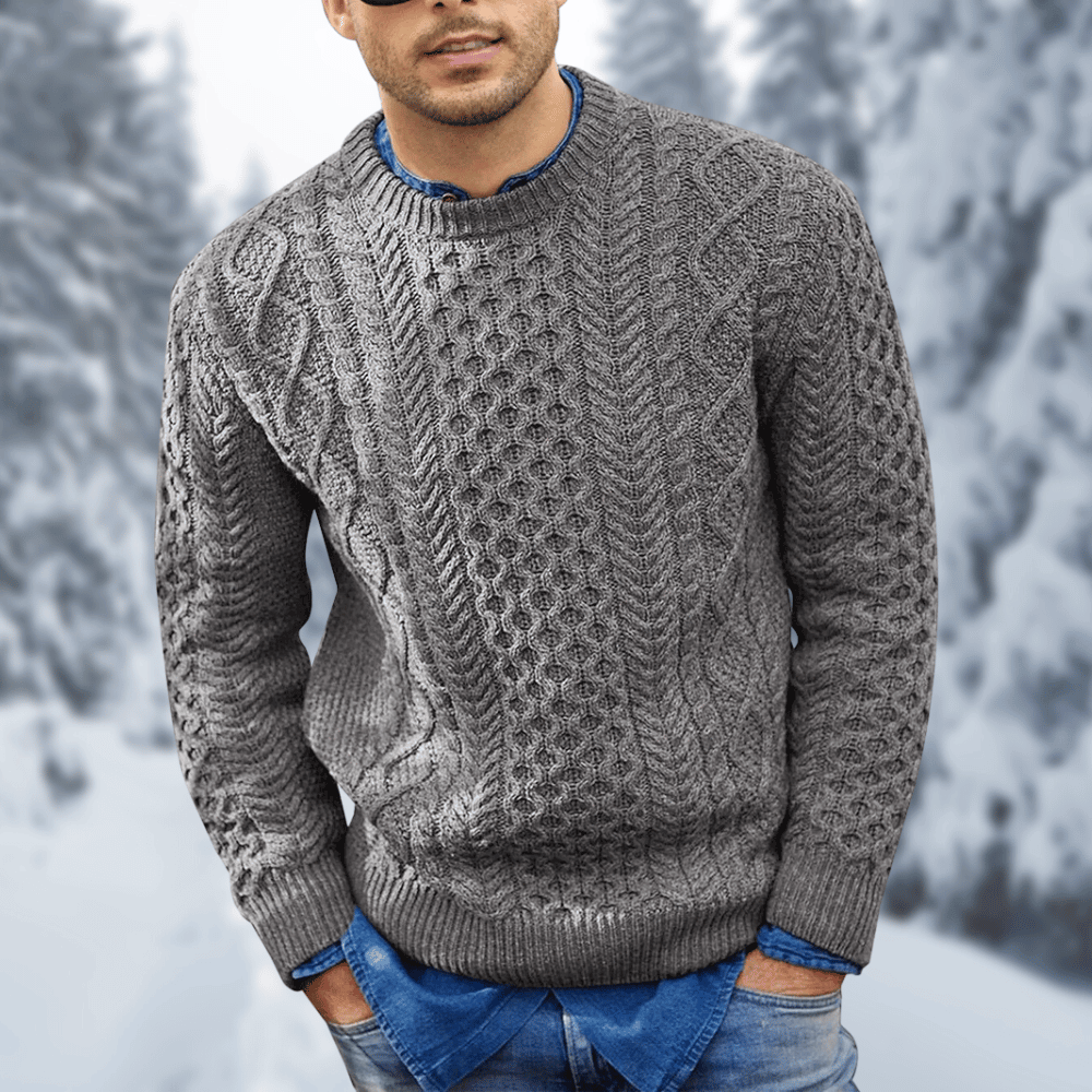 Maglione uomo grigio in lana intrecciata, stile casual invernale, indossato su camicia blu, sfondo innevato. Moda maschile, abbigliamento caldo.