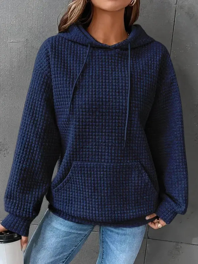 Donna con felpa blu a coste, cappuccio e tasca frontale, indossa jeans chiari. Stile casual, moda autunnale, abbigliamento comodo.