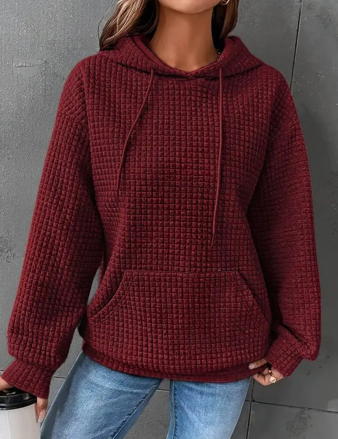 Felpa donna con cappuccio, colore bordeaux, tessuto a trama waffle, tasca frontale, maniche lunghe, abbinata a jeans. Moda casual autunno inverno.